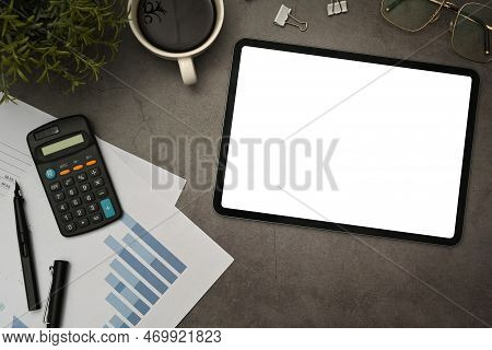 Tablet With Empty Display, Calculator, Financial Reports And Supplies On Black Slate Texture Backgro