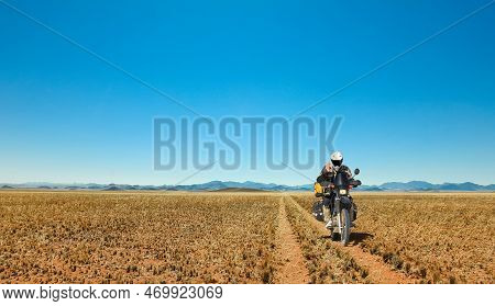 One Motorbiker Driving On Dirt Road Through Grasland Desert. Motorcycle Adventure In Namib, Namibia.