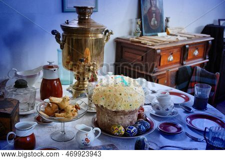 Festive Easter Table With An Old Samovar And Easter Cake On The Background Of An Icon