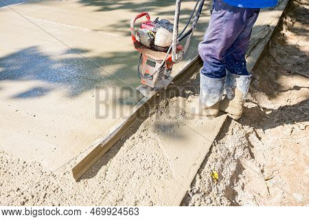 Construction Worker Is Wearing Gloves As Leveling Fresh Concrete With Motor Power Tool, Vibration Me
