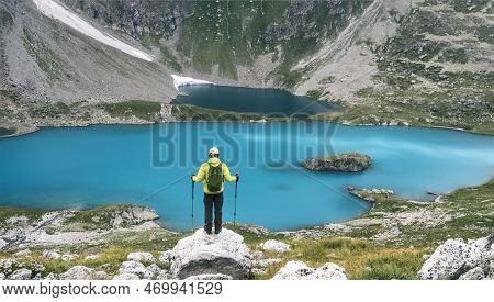 Back View Of Man Traveling With Trekking Poles And Backpack At Imeretinsky Lake Of Silence Backgroun