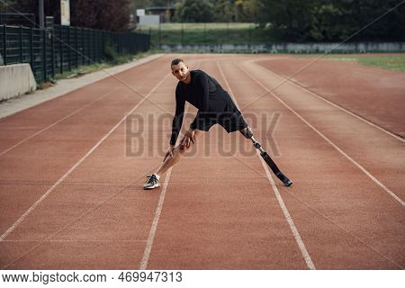 A Sportsman With Artificial Leg Warming Up At Stadium On Running Track.