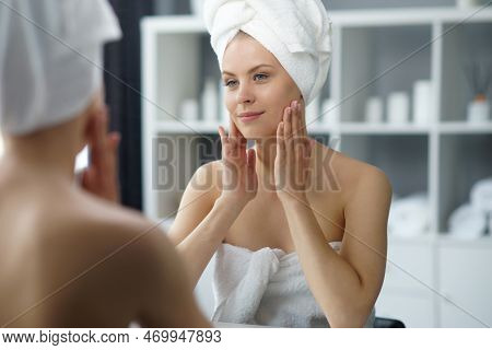 Young Woman Sits In The Bathroom In Front Of The Makeup Mirror And Does Cosmetic Procedures. Beautif