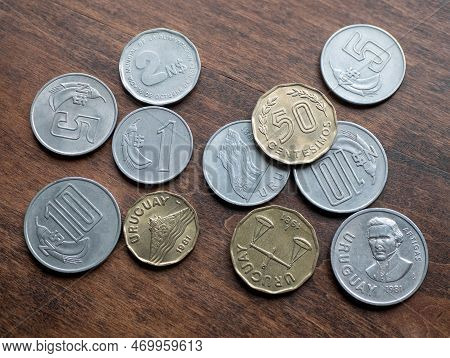 Coin Money Of Uruguay On Wooden Background, Close Up. Nuevos Peso And Centesimos Coins. Concept Of D