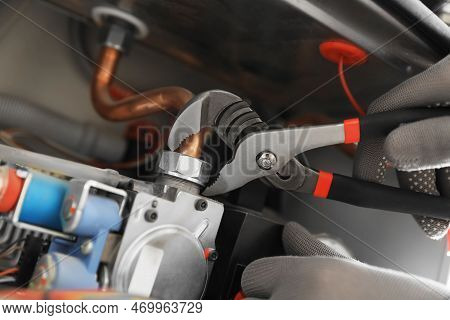 Man Repairing Gas Boiler With Waterpump Plier, Closeup