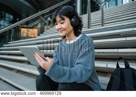 Smiling Chinese Student Sits On Stairs With Tablet, Draws Digital Art, Graphic Design Project For Fr