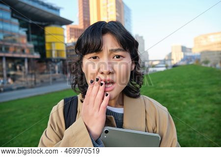 Close Up Portrait Of Girl With Tablet, Looks Worried, Concerned Face Expression, Feels Sad For Someo