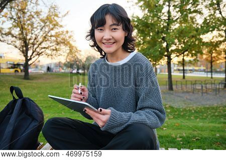 Portrait Of Young Smiling Korean Girl, Graphic Designer, Artist Drawing On Digital Tablet With A Pen