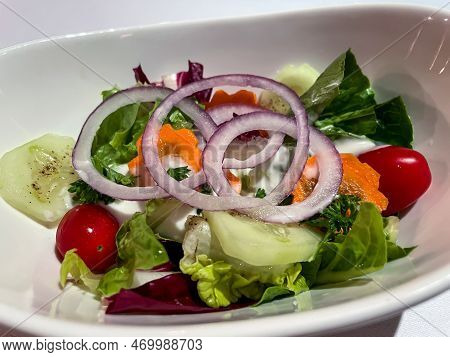 A Salad Plate Full Of A Mixed Salad And Beautiful Onion Rings.