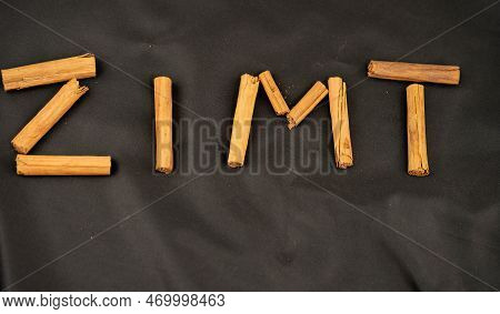 Dried Cinnamon Sticks And Powder On Olive Wood