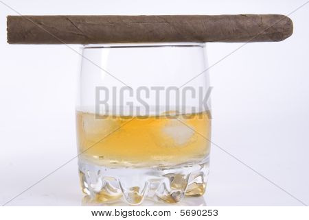 Verre de whisky avec des glaçons et cigare