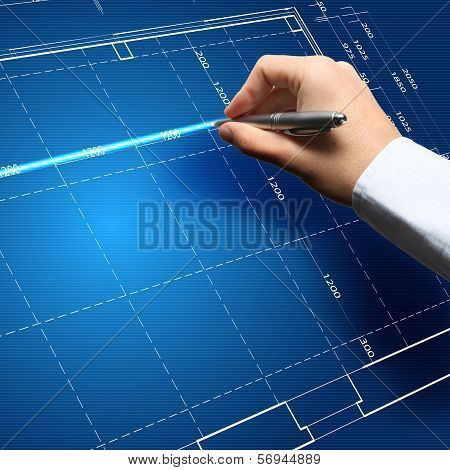 Hand and blueprint - engineer working on blue print concept