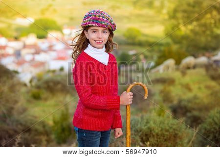 Kid girl shepherdess smiling with wooden baston in Spain village