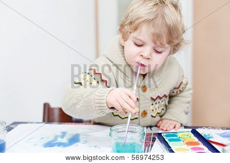 Cute Toddler Boy Having Fun Indoor, Painting With Different Paints Colors.