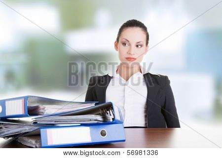 Sad woman with ringbinders sitting at the desk. Tired and exhousted business woman. 
