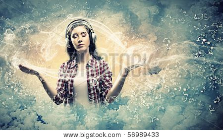 Image of young pretty woman with headphones meditating