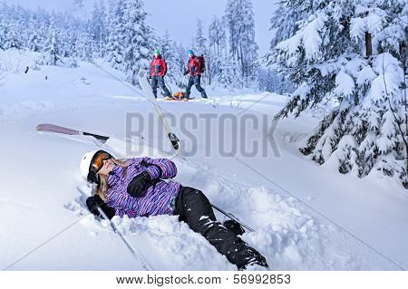 Skier after accident waiting for mountain rescue lying in snow