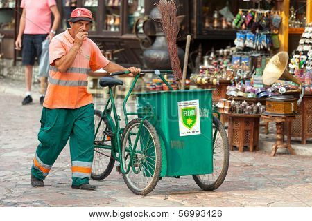 SARAJEVO, BOSNIA AND HERZEGOVINA - AUGUST 13, 2012: waste collector pushes trolley on Bascarsija, the old town, very popular tourist place.