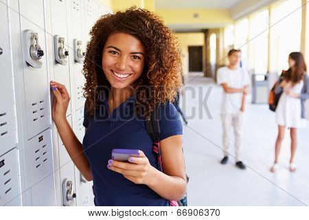 Female High School Student By Lockers Using Mobile Phone