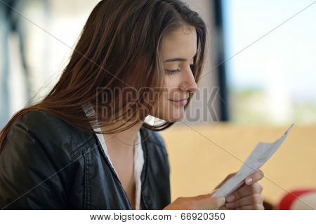 beautiful young woman relax and work on laptop computer while listening music on heaphones and read book at home