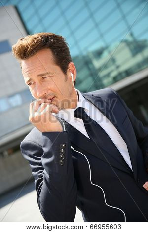 Businessman talking on phone outside building