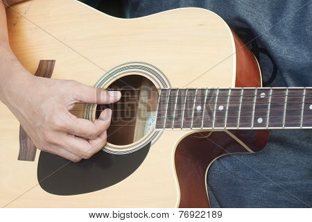 Guitarist playing folk song with old guitar