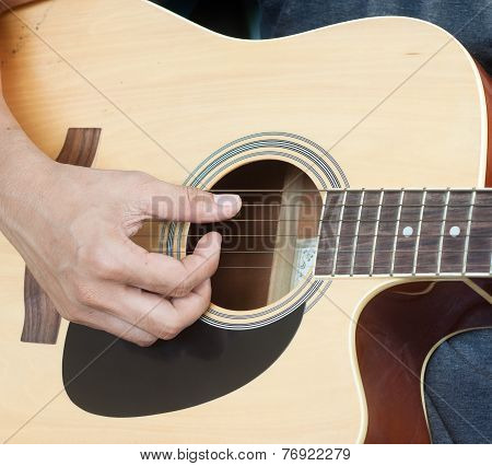 Guitarist playing folk songs with old guitar