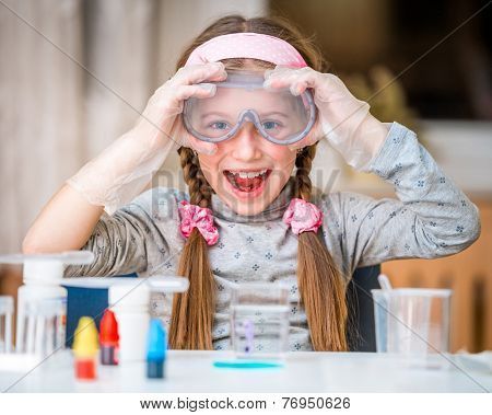 happy little girl with flasks for chemistry