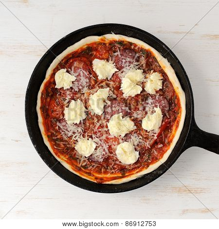Raw Round Pizza With Salami, Onion, Mozarella In Cast Iron Skillet
