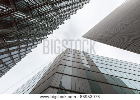 A photo looking up capturing three different buildings on an angle