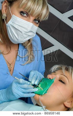 dentist at work with patient, exam, cleaning, curing, using dental water jet