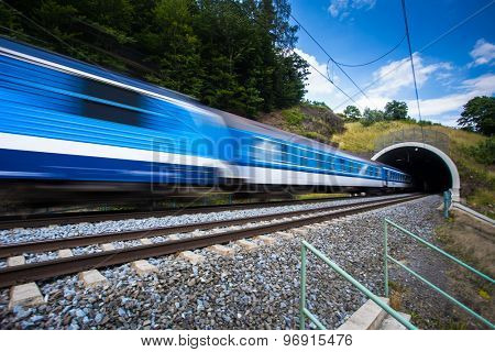Fast train passing through a tunnel on a lovely summer day (motion blurred image)