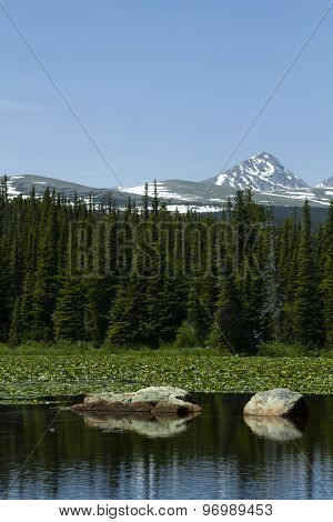 Dramatic Red Rock Lake With Huge Stones, Forest, And Mountains