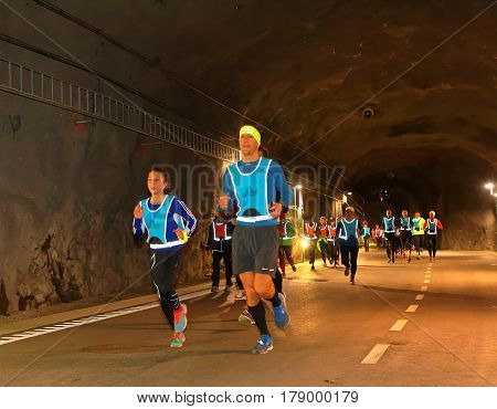 STOCKHOLM SWEDEN - MAR 25 2017: Group of runners in reflex vest in a dark tunnel in the Stockholm Tunnel Run Citybanan 2017. March 25 2017 in Stockholm Sweden