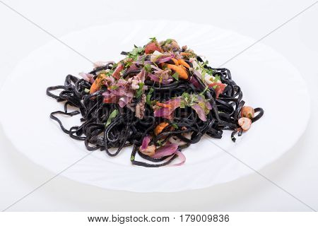 Black spaghetti with seafood and vegetables .