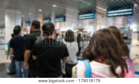Blurred Defocused Image Of Group Travellers Queue At Immigration Control At Airport For Background.