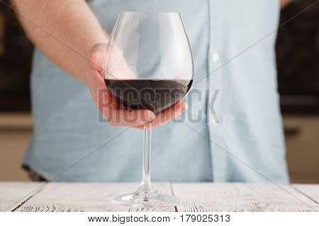 Leisure, Drinks And Lifestyle Concept - Close Up Of Male Hand Holdind Glass Of Red Wine
