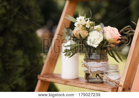 Wedding bouquet of yellow and white roses and blue fresia lying on wooden floor.