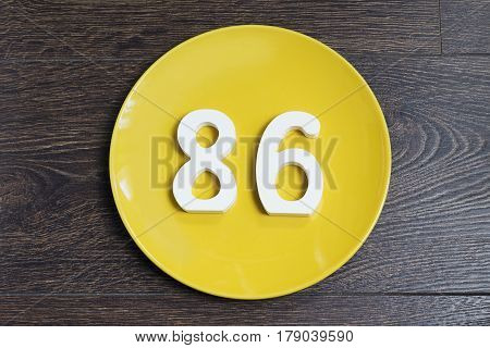 The number eighty-six on the plate yellow and brown background.