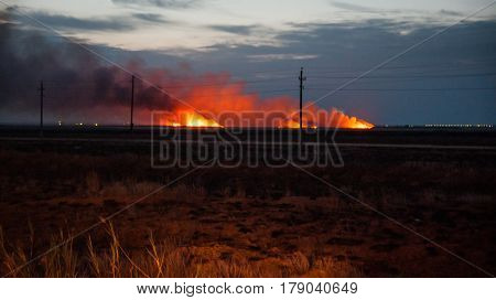 Large scale flames of burning grass in the nightfall, Ahtuba, Russia