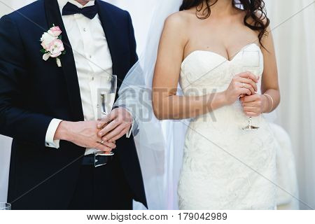 Wedding Couple Hold Glasses With Champagne In Their Arms