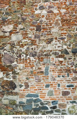 Closeup view of old wall of medieval castle made of red bricks and stone
