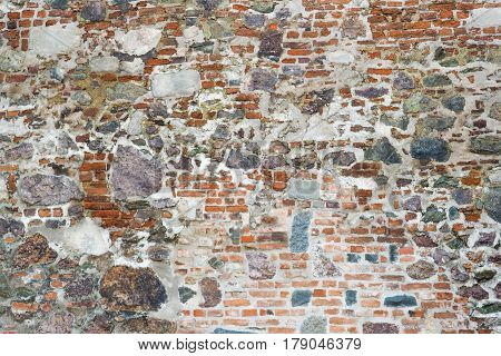 Closeup view of old wall of medieval castle made of red bricks and stone