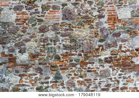 Closeup view of old wall of medieval castle made of red bricks and stone