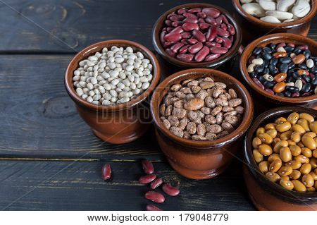 Assortment of beans on black wooden background. Soybean red kidney bean black beanwhite bean red bean and brown pinto beans