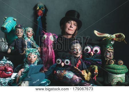 Puppeteer woman standing between her handmade puppets.