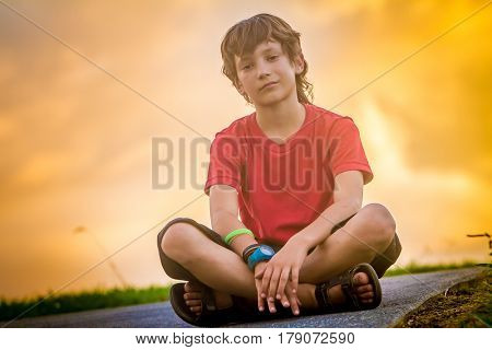 outdoor portrait of young teen boy on sunset natural background