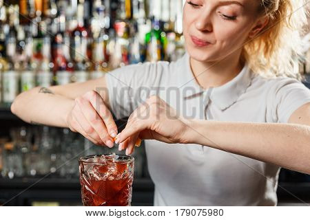 Woman bartender making an alcohol cocktail at the bar