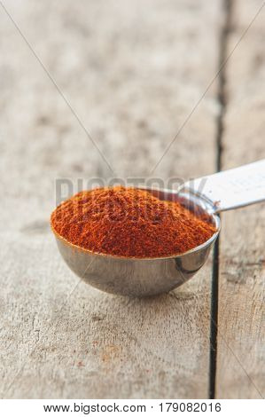 Powdered red pepper pile close up on wood