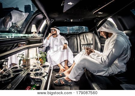 Arabic businessmen in Dubai driving on a limousine